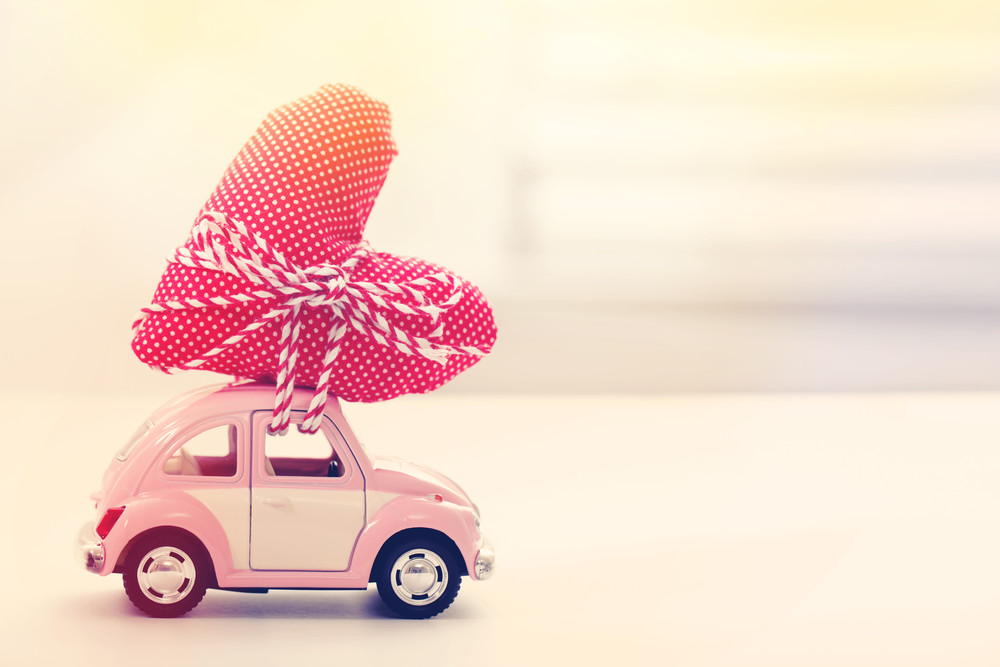 Lieferzeit - Spielzeugauto mit einem Herz auf dem Dach Lieferzeit - Spielzeugauto mit einem Herz auf dem Dach